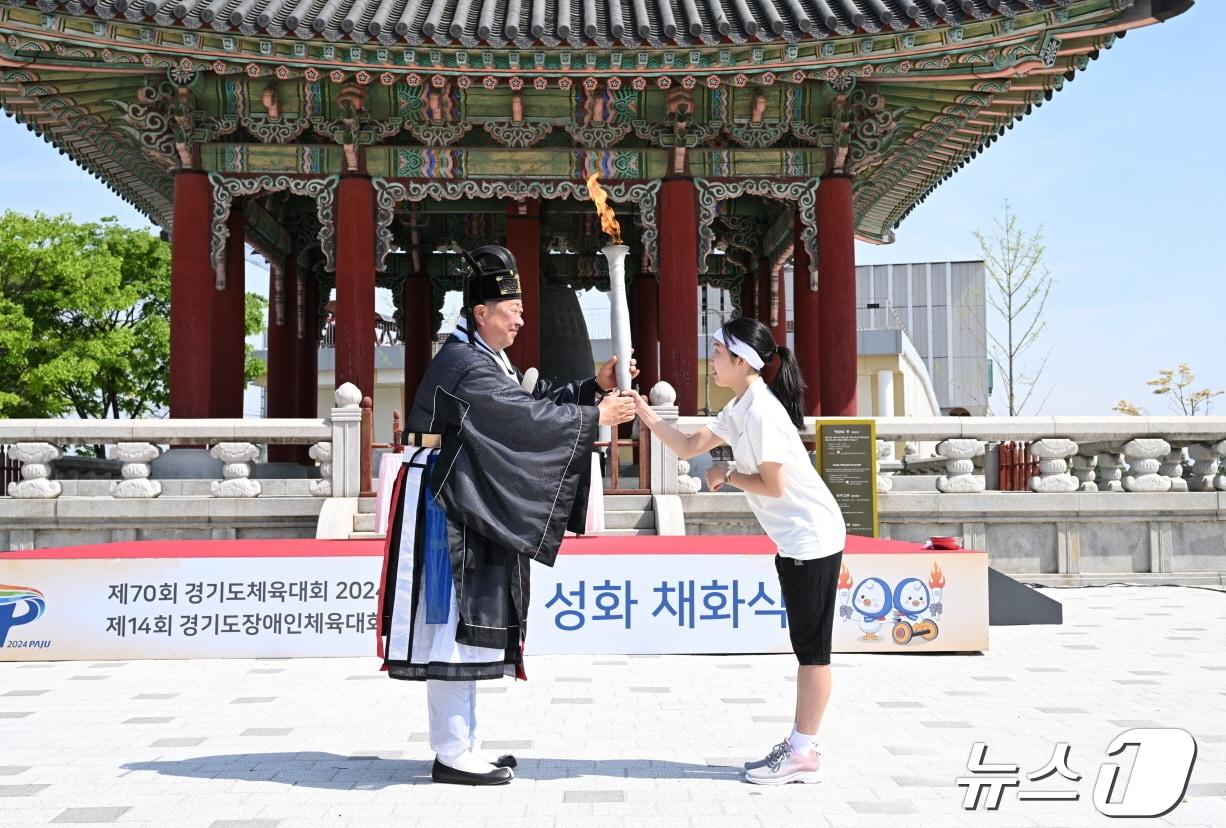 본문 이미지 - 23일 파주 임진각 평화의 종 광장에서 열린 경기도체육대회 성화 채화식에서 김경일 파주시장이 채화된 성화를 장한나 양(교하중)에게 전달하고 있다. (파주시 제공)