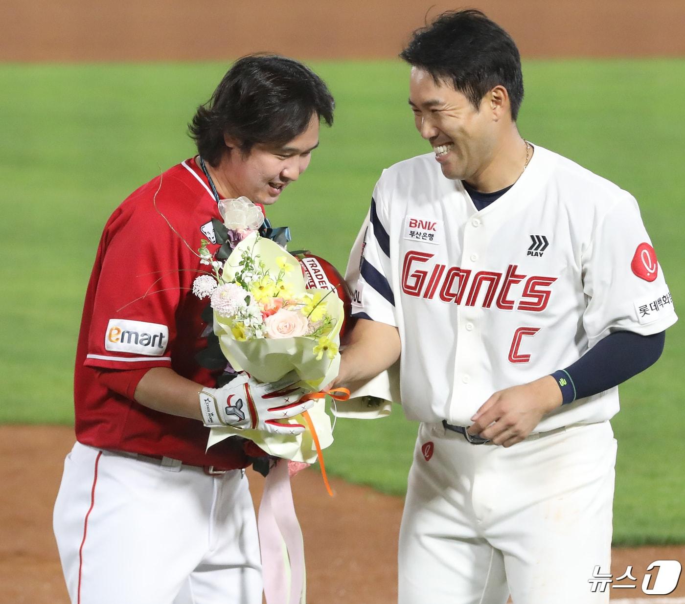 본문 이미지 - 24일 오후 부산 사직야구장에서 열린 '2024 신한 SOL 뱅크 KBO리그' 롯데 자이언츠와 SSG 랜더스의 경기, 5회초 2사 주자 없는 상황 SSG 최정이 468호 홈런으로 KBO리그 통산 최다 홈런 신기록을 달성한 뒤 꽃다발을 들고 전준우와 기쁨을 나누고 있다. 2024.4.24/뉴스1 ⓒ News1 윤일지 기자