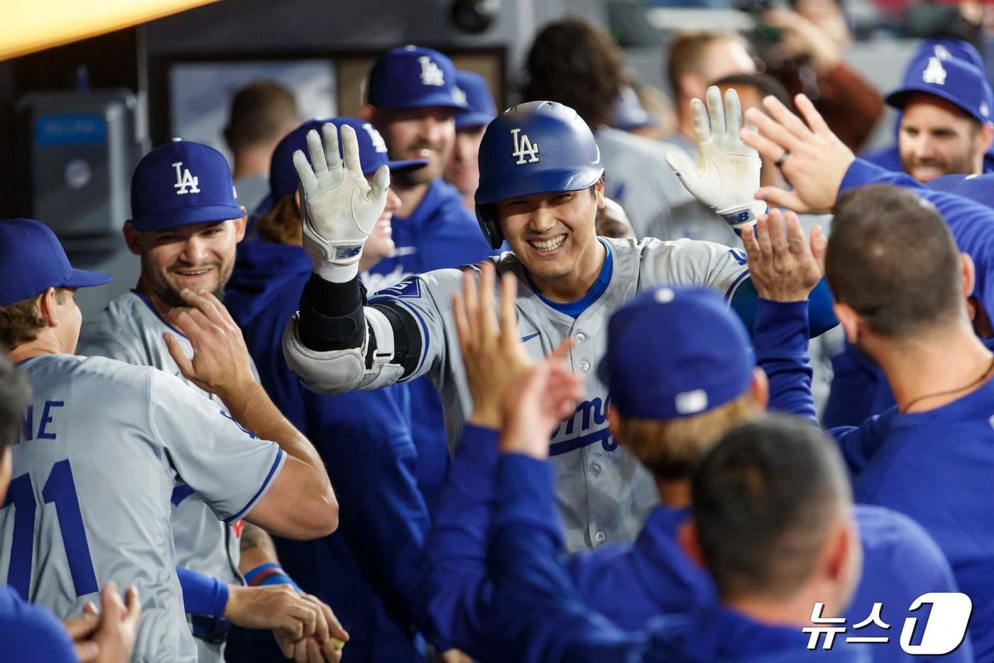 LA 다저스 오타니 쇼헤이가 27일(한국시간) 캐나도 온타리오주 토론토 로저스 센터에서 열린 메이저리그(MLB) 토론토 블루제이스와 경기에서 홈런을 친 뒤 동료들의 축하를 받고 있다. ⓒ AFP=뉴스1