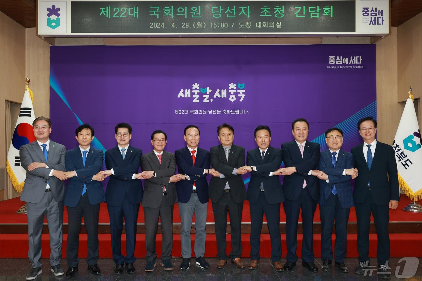 본문 이미지 - 김영환 충북지사와 22대 총선 국회의원 당선인들이 29일 도청 대회의실에서 열린 간담회에 앞서 손을 맞잡고 기념촬영을 하고 있다. (충북도 제공)