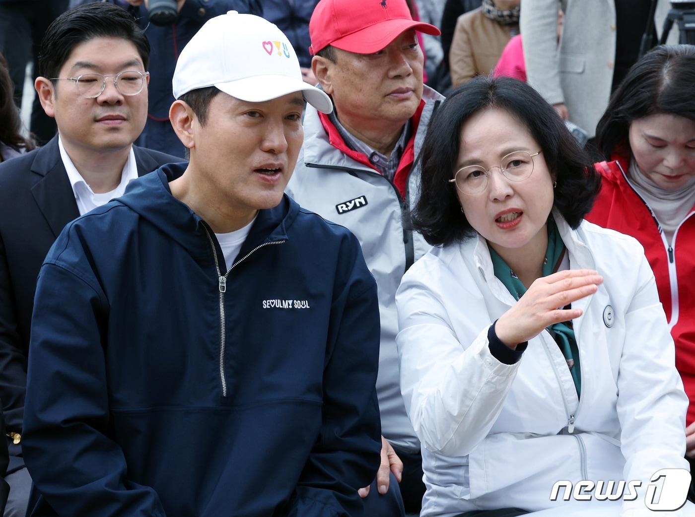 본문 이미지 - 오세훈 서울시장이 3일 오후 서울 강동구 암사동 암사역사공원에서 열린 제79회 식목일 기념 '동행매력 정원도시 서울' 만들기 행사에서 이수희 강동구청장과 대화를 나누고 있다. 2024.4.3 ⓒ 뉴스1 박정호 기자