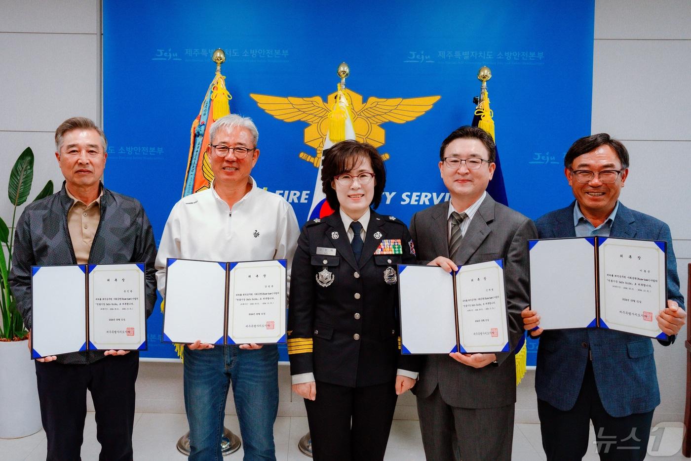 본문 이미지 -  고민자 제주소방안전본부장(가운데)과 퇴직소방관들로 구성된 '전통시장 세이프 가이드' 참가자들이 기념촬영을 하고 있다(제주소방안전본부 제공)/뉴스1