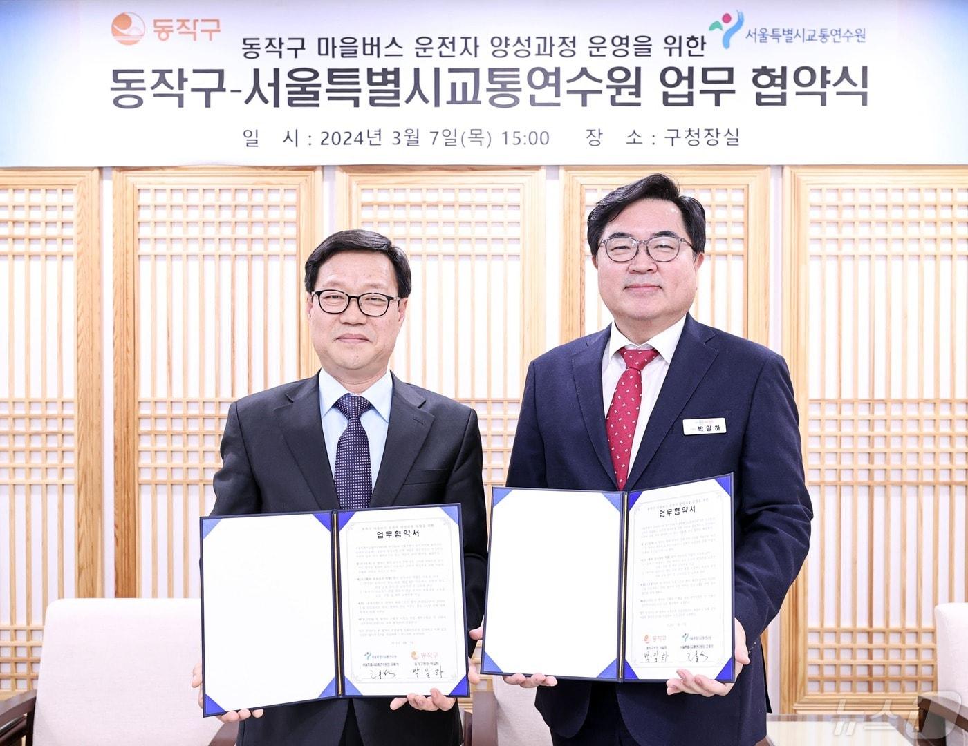 본문 이미지 - 박일하 동작구청장(사진 오른쪽)은 지난 달 7일 동작구청에서 고홍석 서울시교통연수원장과 ‘동작구 마을버스 운전자 양성과정 운영을 위한 업무협약(MOU)’를 체결했다. (동작구 제공)ⓒ 뉴스1