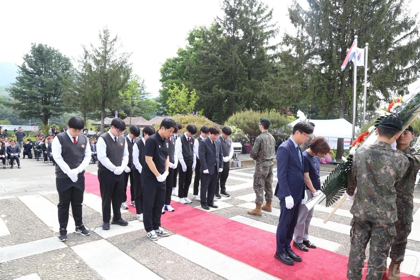 본문 이미지 -  삼일공업고 김동수 교장과 학생들이 네델란드군 참전기념비에 헌화한 뒤 묵념을 하고 있다. (삼일공고 제공) ⓒ 뉴스1