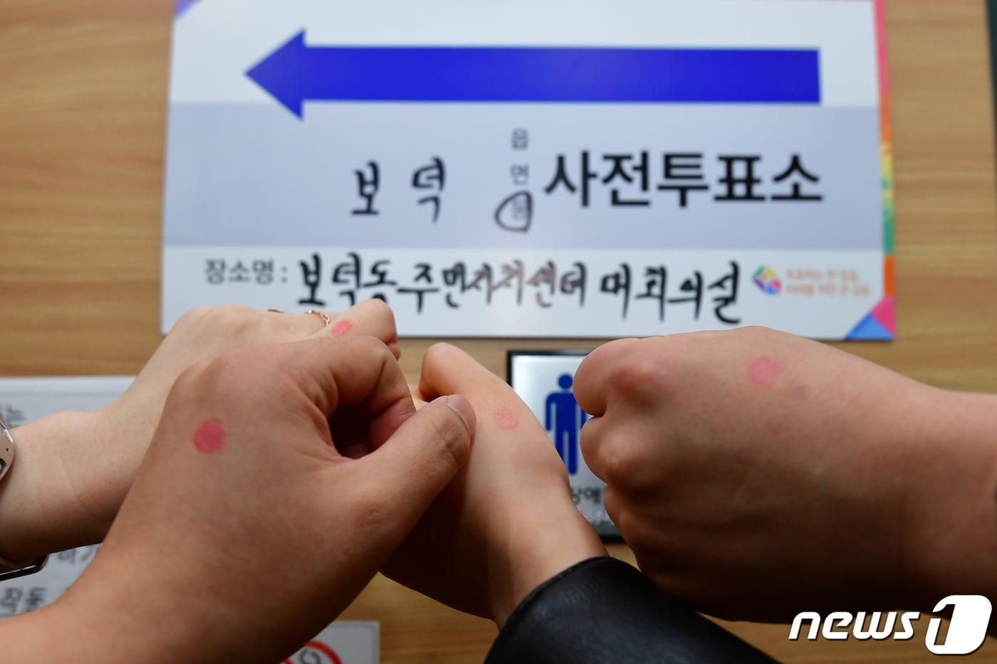 제22대 국회의원선거 사전투표일 이틀째인 6일 오전 경북 경주시 보덕동 사전투표소에서 제31회 경주벚꽃마라톤대회에 참가한 유권자들이 사전 투표를 한 후 인증을 남기고 있다. 2024.4.6/뉴스1 ⓒ News1 최창호 기자