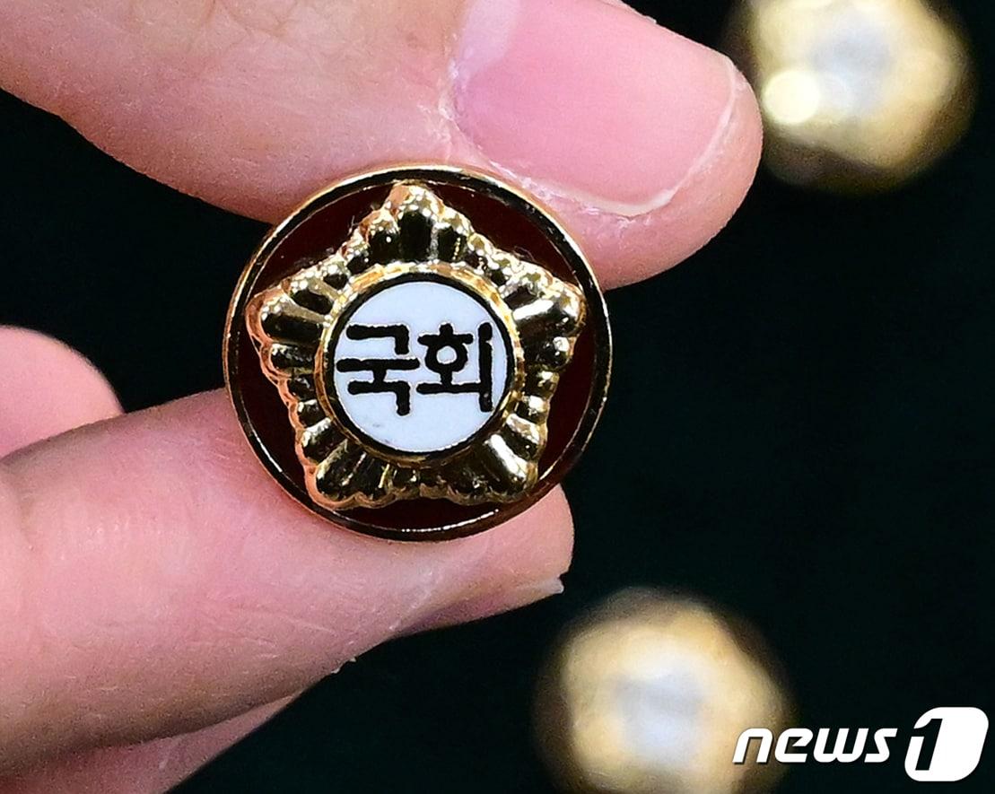 본문 이미지 - 총선을 이틀 앞둔 8일 서울 여의도 국회 의원회관에서 열린 제22대 국회 개원종합지원실 현판식에서 국회사무처 직원들이 제22대 국회의원들이 착용할 국회 배지를 공개하고 있다. (공동취재) 2024.4.8/뉴스1 ⓒ News1 송원영 기자