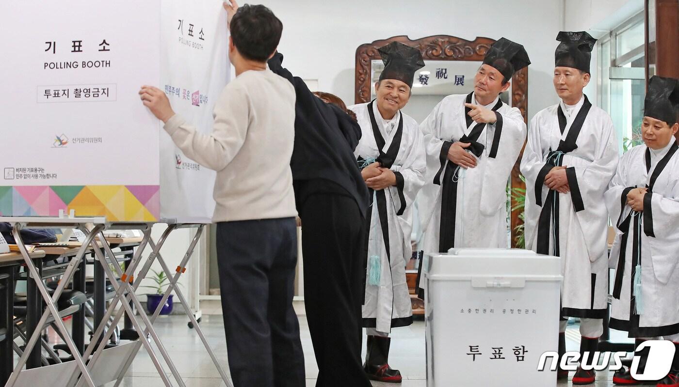 본문 이미지 - 제22대 국회의원선거를 하루 앞둔 9일 오후 대구 중구 남산동 대구향교 소강당에서 중구청 관계자들의 투표소 설치 작업을 향교 유림이 신기한 듯 바라보고 있다. 설치가 완료되면 투표소 출입은 통제되고 투표 개시 전 선거사무원들의 이상 유무 점검 후 투표가 시작된다. 2024.4.9/뉴스1 ⓒ News1 공정식 기자
