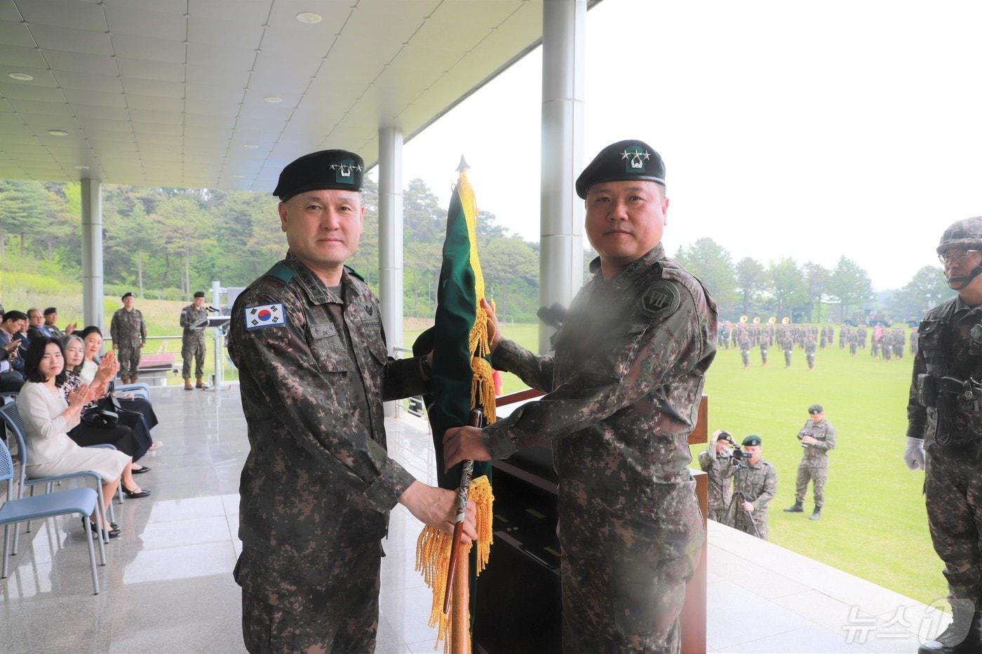 육군 제7기동군단장 이·취임식에서 손식 지상작전사령관(왼쪽)이 박재열 신임 7기동군단장에게 부대기를 이양하고 있다.(7군단 제공)