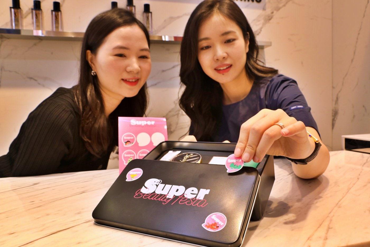 본문 이미지 - 롯데백화점 본점 지하 1층 입생로랑 뷰티 매장에서 모델이 틴케이스를 꾸미고 있다(롯데쇼핑 제공).