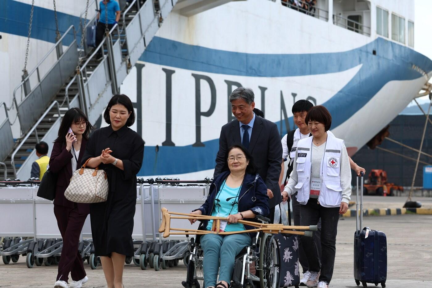 본문 이미지 - 최영한 재외동포청 차장이 동해항으로 영주귀국한 사할린 동포 김옥화 씨의 휠체어를 밀고 있다.(재외동포청 제공)