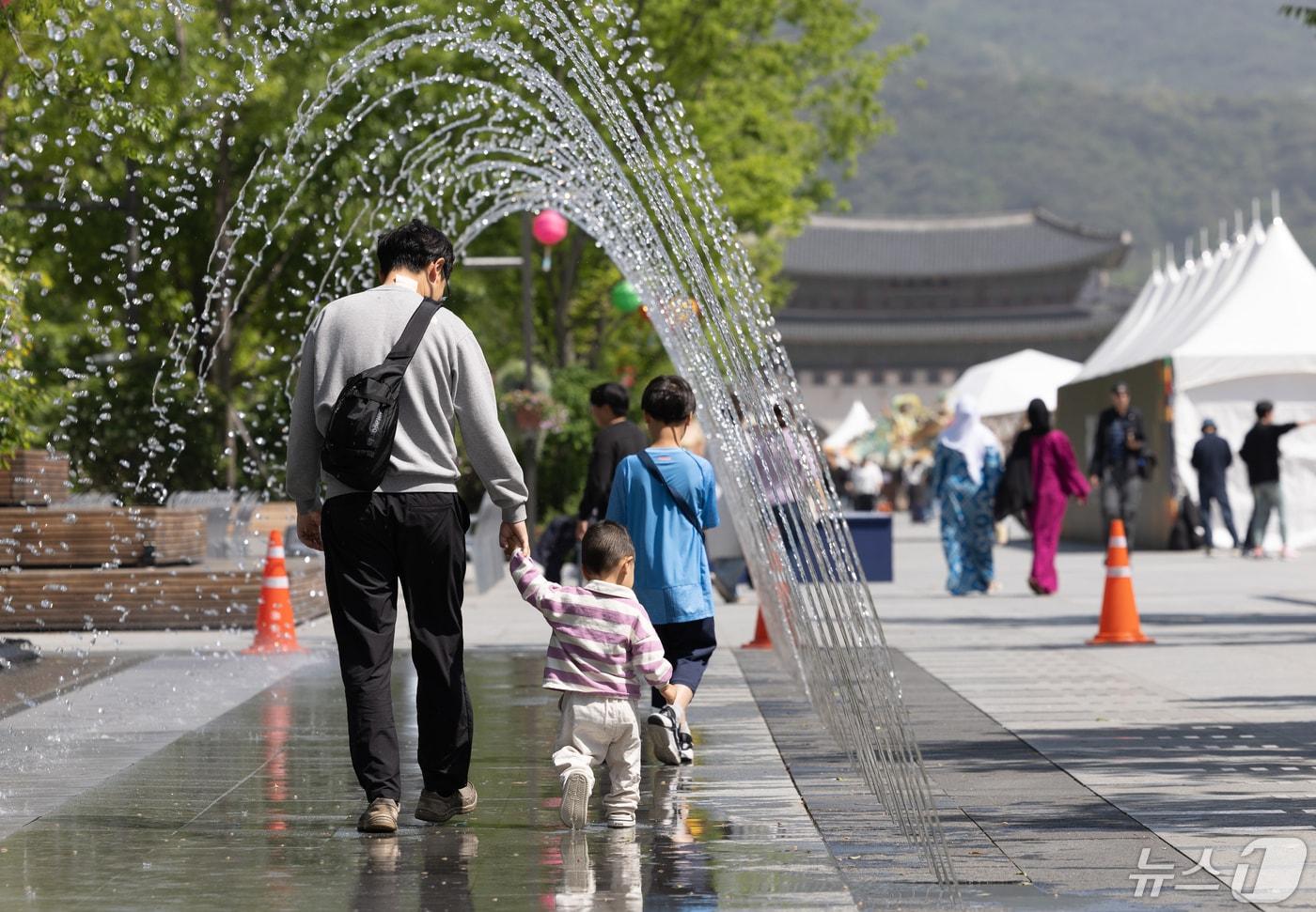 본문 이미지 -  서울 세종대로 광화문광장 분수대를 찾은 한 가족이 즐거운 시간을 보내고 있다. ⓒ 뉴스1 이재명 기자
