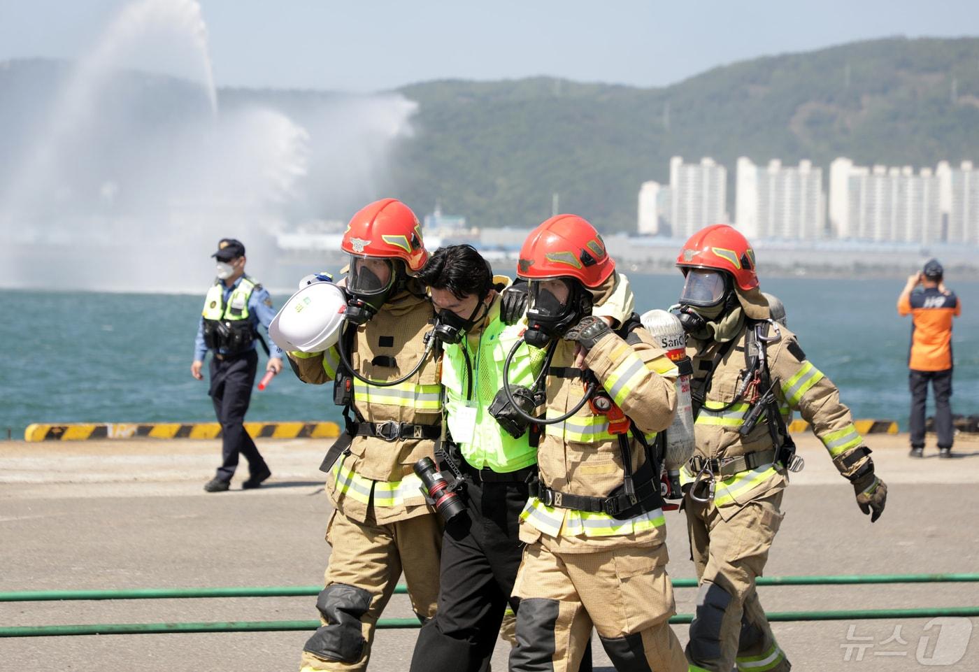 본문 이미지 - 해양수산부와 울산항만공사가 주관한 '2024 재난대응 안전한국 훈련'이 13일 울산항에서 열렸다. 자동차운반선 내 선적된 전기차 화재로 인한 화재 발생 상황을 가정해 훈련이 진행됐다. 소방대원이 발생한 환자를 부축해 신속하게 구조하고 있다.2024.5.13/뉴스1 ⓒ News1 김지혜 기자