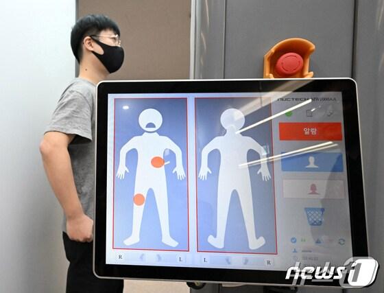 본문 이미지 - 관세청 관계자들이 지난 1월 인천국제공항 제1여객터미널 입국장에서 신체에 은닉한 마약 등을 검색하는 밀리미터파 신변검색기를 시연하고 있다.(인천공항=뉴스1) 장수영 기자