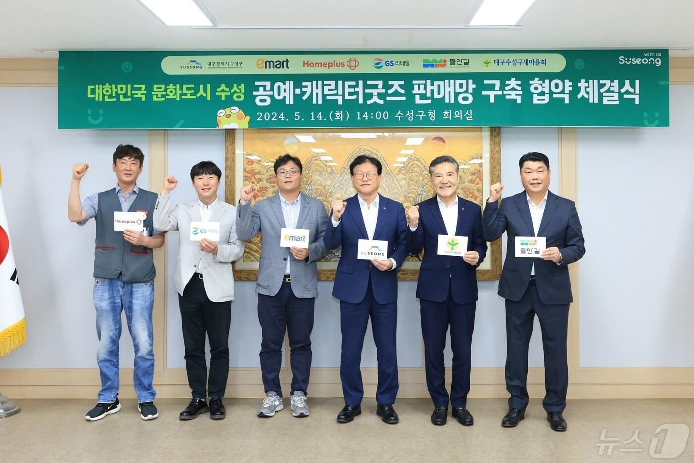 대구 수성구 지난 14일 문화경제 공동체 구축 활성화를 위해 구 대표 캐릭터인 '뚜비' 굿즈 판매망 구축과 활성화 협약을 체결하고 참석자들과 기념 촬영하고 있다.(대구 수성구 제공)