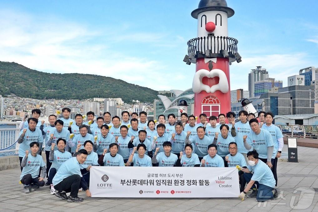본문 이미지 - 부산롯데타워 임직원 60여명이 광복동 일원 길거리 환경 정화 활동 캠페인을 진행하고 기념 촬영을 진행하고 기념사진을 찍고 있다(롯데쇼핑 제공)