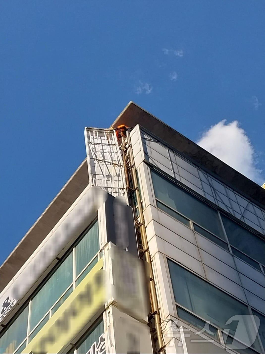 본문 이미지 - 16일 오후 3시 37분쯤 해운대구 우동 한 건물에서 옥상 간판이 흔들려 소방이 안전조치를 하고 있다.(부산소방재난본부 제공) 