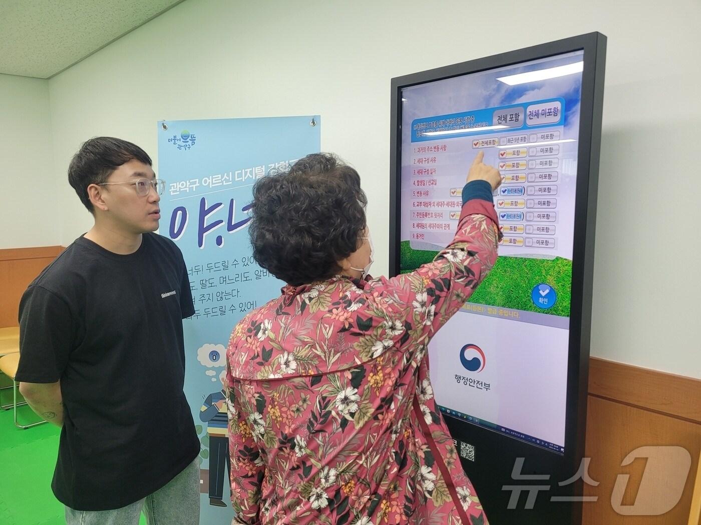 본문 이미지 - 서울 관악구 어르신 디지털 문해교육에 참여해 무인민원발급기 실습 중인 주민.(관악구청 제공)