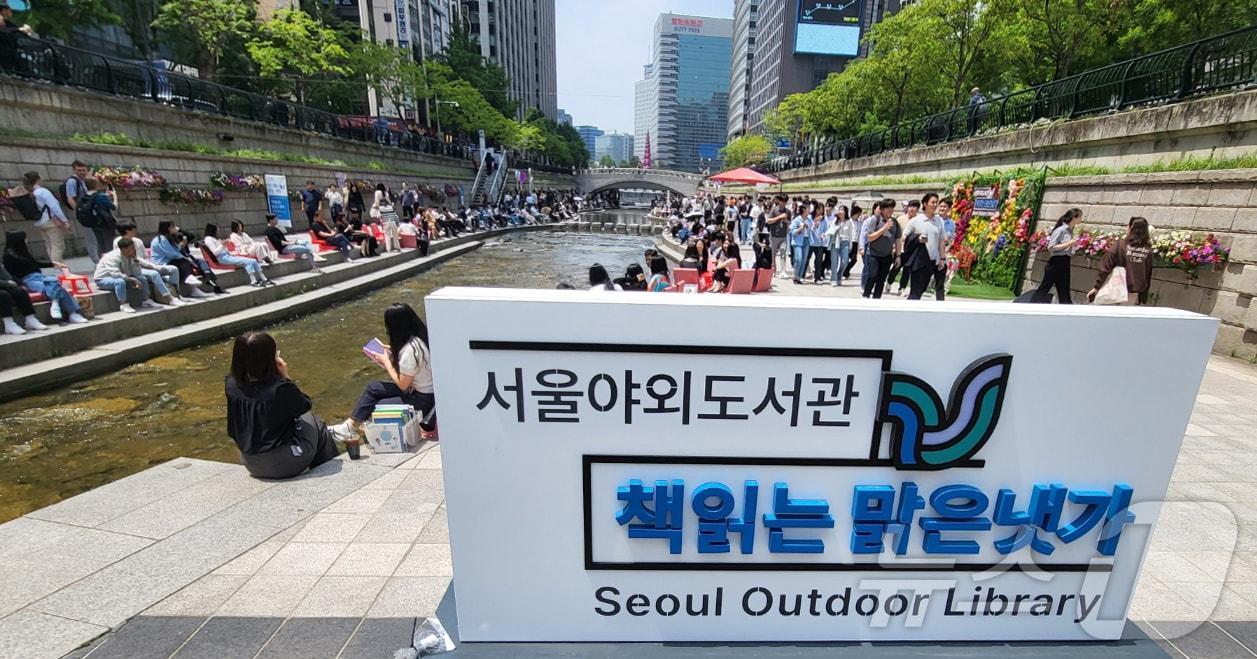본문 이미지 - 서울 청계천에서 열린 서울야외도서관-책 읽는 맑은 냇가에서 시민들이 의자에 앉아 책을 보며 휴식을 취하고 있다. 2024.5.17 ⓒ 뉴스1