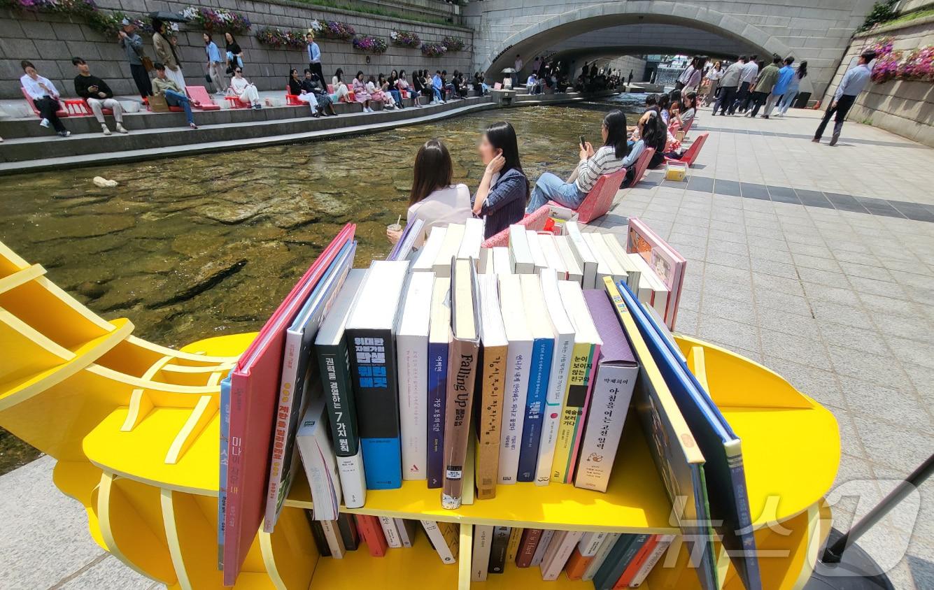 본문 이미지 - 서울 청계천에서 열린 서울야외도서관-책 읽는 맑은 냇가에서 시민들이 의자에 앉아 책을 보며 휴식을 취하고 있다. 2024.5.17/뉴스1