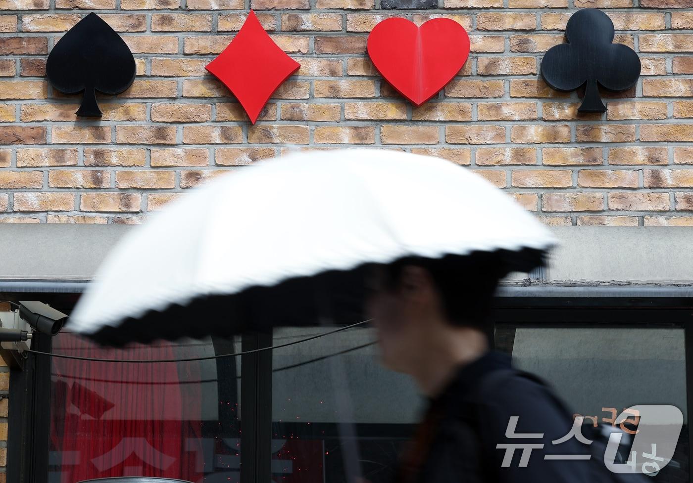 카드 게임의 한 종류인 홀덤 게임을 할 수 있는 홀덤펍과 홀덤카페에 청소년의 출입과 고용이 금지된 17일 서울 도심의 한 홀덤펍 앞으로 시민이 지나고 있다.. 2024.5.17/뉴스1 ⓒ News1 박정호 기자