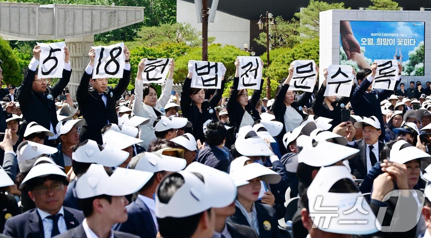 본문 이미지 -  광주 북구 국립5·18민주묘지에서 열린 5·18민주화운동 제44주년 기념식에서 기념사를 하는 가운데 광주시의회 5·18특별위원회 위원들이 '5·18 헌법 전문 수록'이라고 적힌 손팻말을 들고 있다. (공동취재)  ⓒ 뉴스1 안은나 기자
