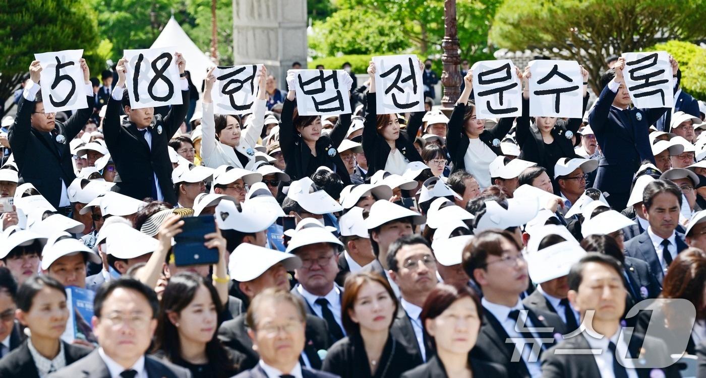 윤석열 대통령이 18일 광주 북구 국립5·18민주묘지에서 열린 5·18민주화운동 제44주년 기념식에서 기념사를 하는 가운데 광주시의회 5·18특별위원회 위원들이 '5·18 헌법 전문 수록'이라고 적힌 손팻말을 들고 있다. (공동취재) 2024.5.18/뉴스1 ⓒ News1 안은나 기자