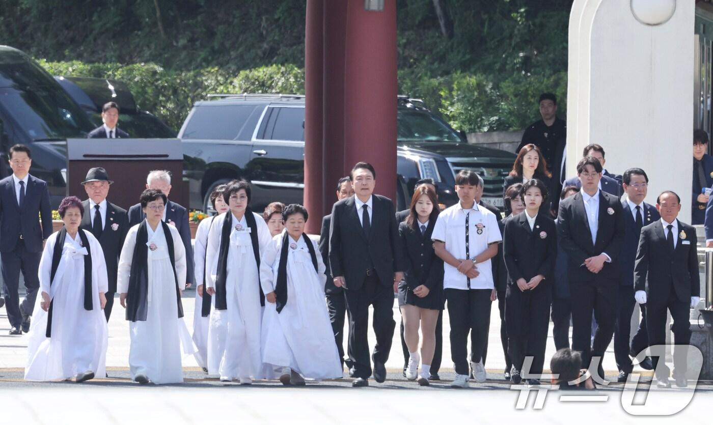 본문 이미지 - 윤석열 대통령이 18일 오전 광주 북구 운정동 국립5·18민주묘지에서 열린 제44주년 5·18 민주화운동 기념식에서 유가족과 입장하고 있다. 2024.5.18/뉴스1 ⓒ News1 김태성 기자