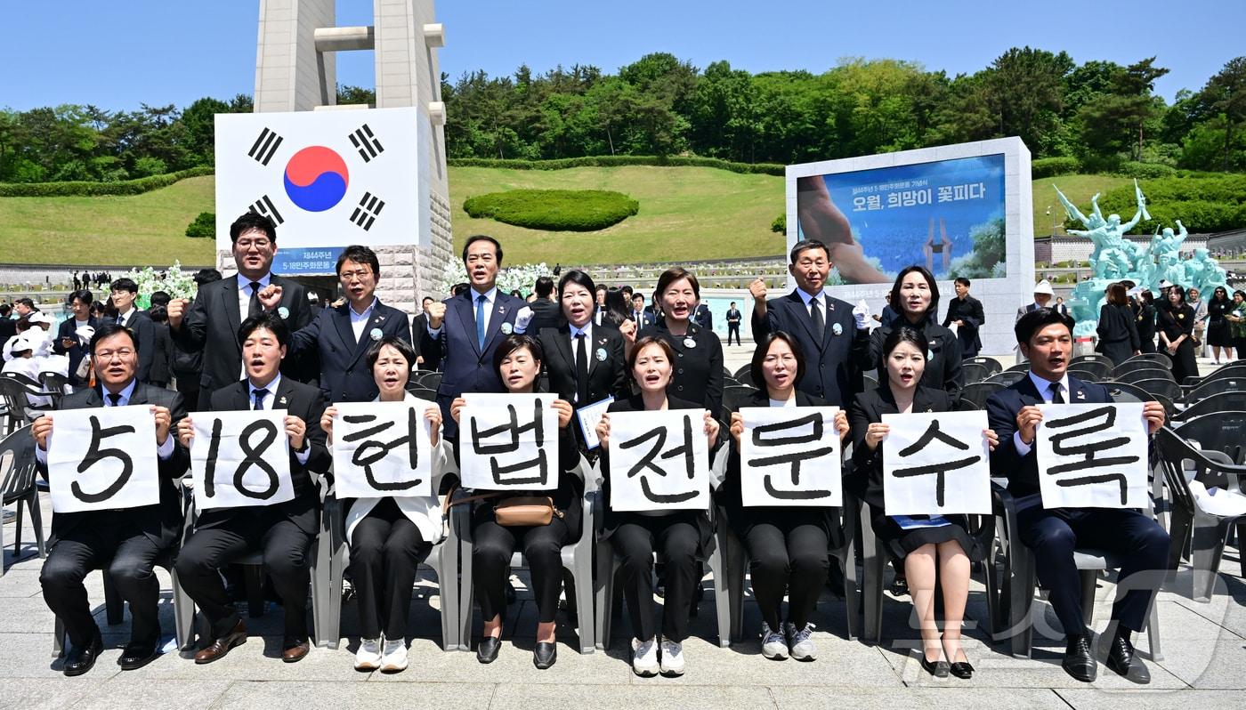 본문 이미지 - 광주시의회 5·18특별위원회 위원들이 지난 2024년 5월18일 광주 북구 국립5·18민주묘지에서 5·18민주화운동 제44주년 기념식을 마친 뒤 '5·18 헌법 전문 수록'이라고 적힌 손팻말을 들고 있다. (공동취재) 2024.5.18 ⓒ 뉴스1 안은나 기자