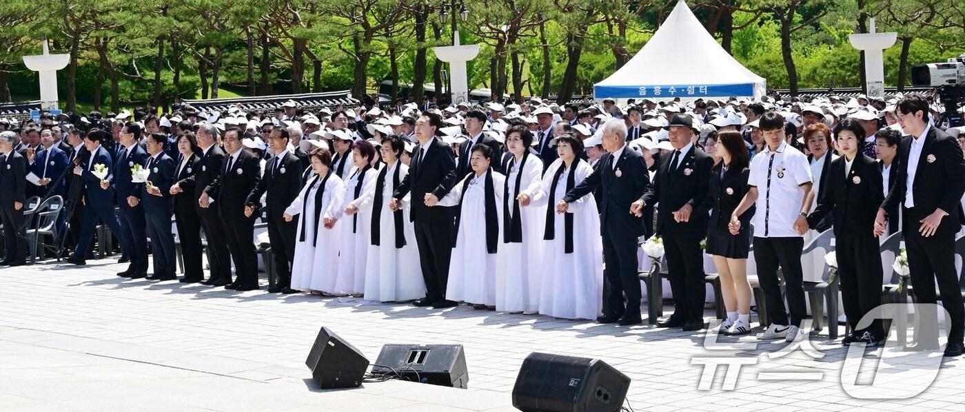 윤석열 대통령이 18일 광주 북구 국립5·18민주묘지에서 열린 5·18민주화운동 제44주년 기념식에서 유가족의 손을 잡고 '임을 위한 행진곡'을 부르고 있다. (공동취재) 2024.5.18/뉴스1 ⓒ News1 안은나 기자