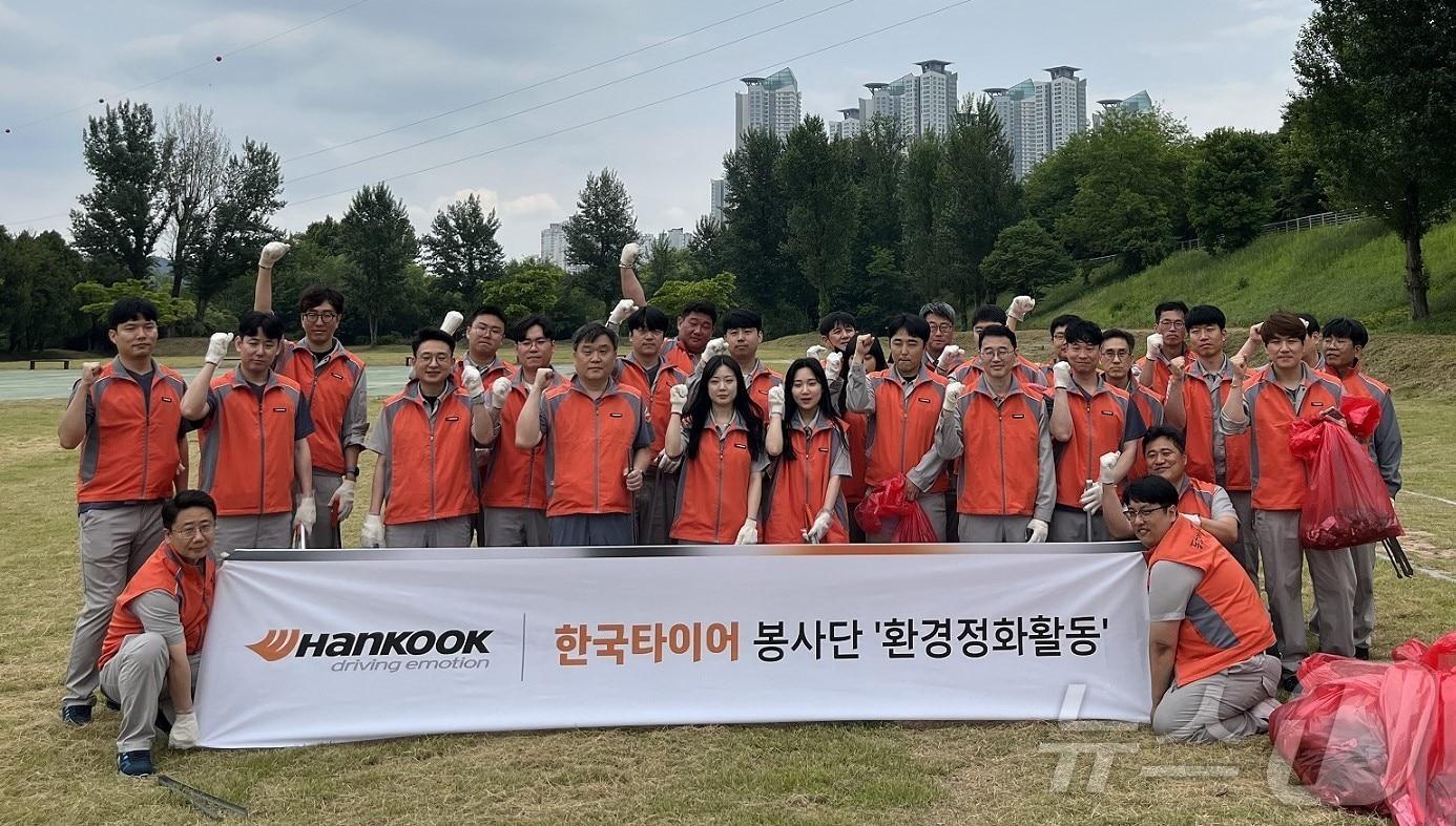 본문 이미지 - 대전 대덕구 금강로하스길 일대에서 환경정화활동을 벌인 한국타이어 임직원들이 단체 사진을 찍고 있다. (한국타이어 제공) /뉴스1