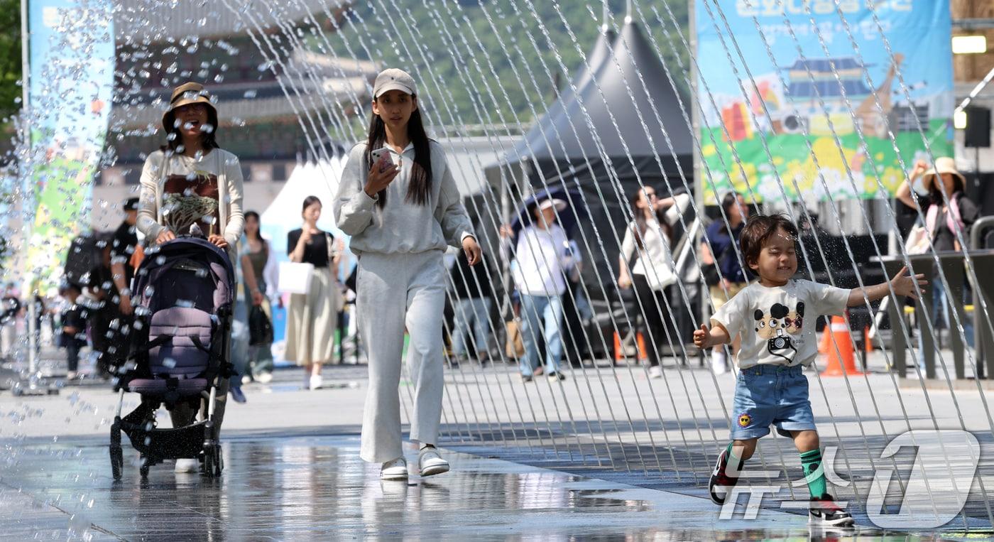 초여름 날씨를 보인 21일 서울 광화문 광장 분수대에서 아이가 물놀이를 하며 더위를 식히고 있다. 2024.5.21/뉴스1 ⓒ News1 김명섭 기자