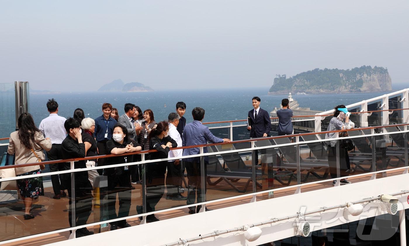 제주 서귀포시 강정동 강정크루즈여객터미널 앞에 정박한 한 크루즈선에서 관광객들이 아름다운 제주의 풍경을 즐기고 있다.ⓒ News1 오미란 기자