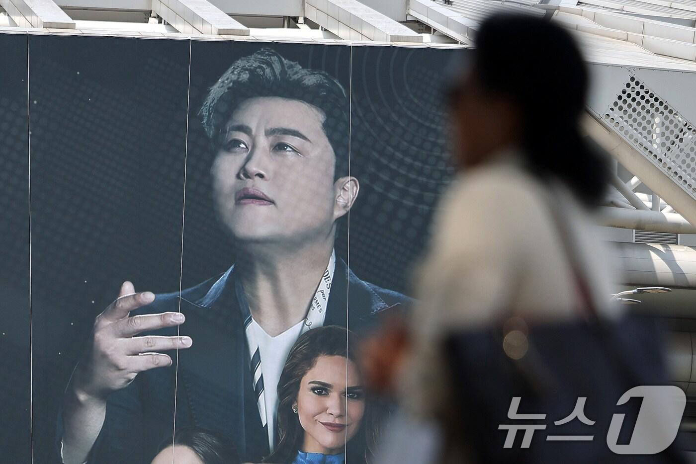 본문 이미지 - 22일 오후 서울 송파구 올림픽공원 KSPO돔(체조경기장)에 설치된 '월드 유니온 오케스트라 슈퍼 클래식 : 김호중 & 프리마돈나’ 현수막 앞으로 시민들이 지나가고 있다.  ⓒ News1 박지혜 기자