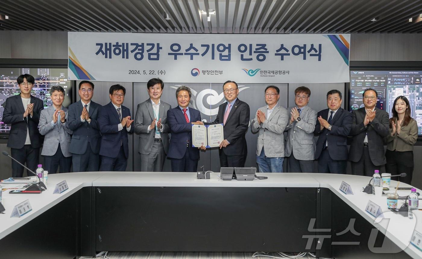 본문 이미지 - 이학재 인천국제공항공사 사장이 지난 22일 인천공항 통합운영센터 회의실에서 열린 ‘재해경감 우수기업 인증서 수여식’에서 이한경 행정안전부 재난안전관리본부장에게 인증서를 받고 기념촬영을 하고 있다. (인천공항공사 제공) 2024.5.23/뉴스1