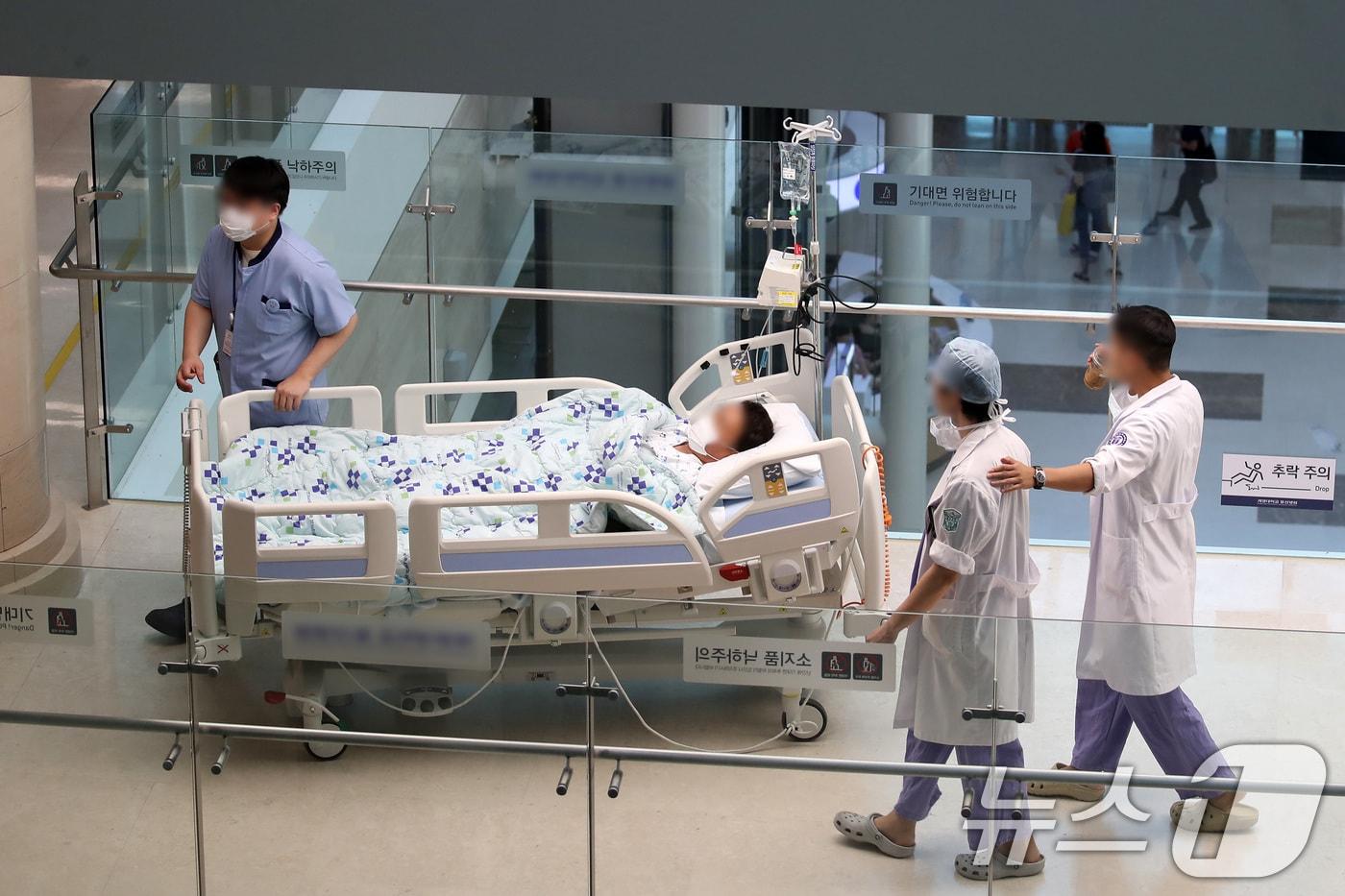 본문 이미지 - 의대 증원을 둘러싼 의·정 갈등이 3개월을 넘으며 의료 공백이 장기화하는 가운데 23일 대구의 한 대학병원 수술센터 앞에서 의료진이 환자 베드를 따라 이동하고 있다. (사진은 기사 내용과 무관함) 2024.5.23/뉴스1 ⓒ News1 공정식 기자