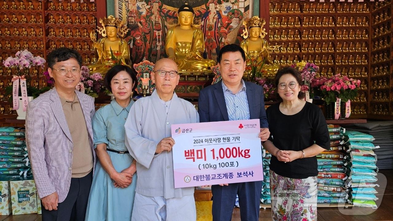본문 이미지 - 금산 부석사 장곡 스님(가운데)이 부처님오신날을 맞아 신도들이 십시일반 모아 준비한 백미를 심완보 부군수(오른쪽 두번째)에게 전달한 후 기념사진을 찍고 있다.(금산군 제공)/ 뉴스1
