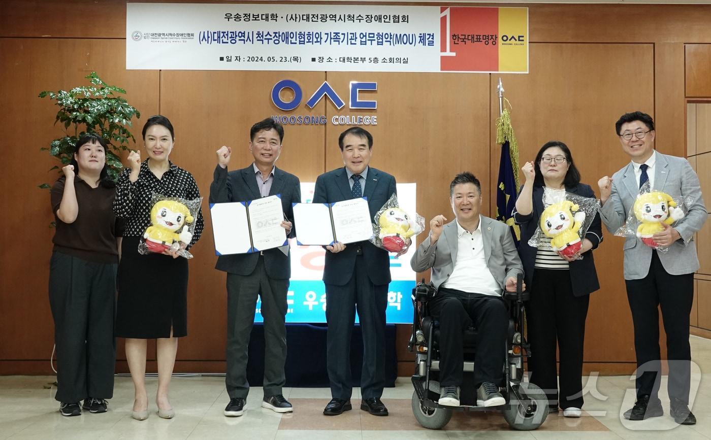  지난 23일 우송정보대에서 남정우 대전척수장애인협회 사무처장(왼쪽 세번째)과 이달영 총장(오른쪽 네번째) 등 관계자들이 재활분야 산학 연계교육을 골자로 하는 업무협약을 맺고 기념사진을 찍고 있다. (우송정보대)/뉴스1