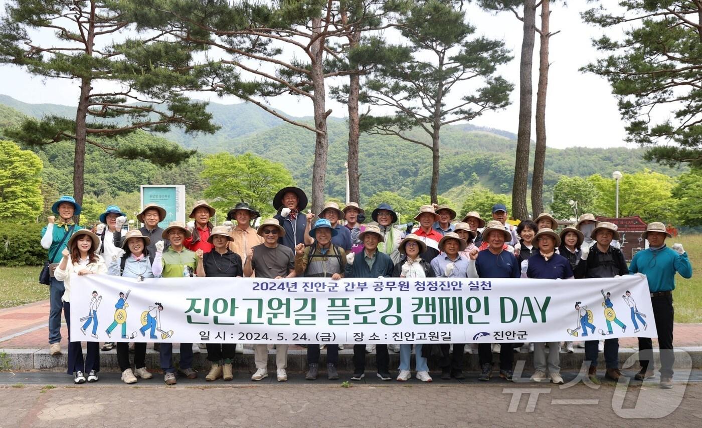 본문 이미지 - 24일 전춘성 전북자치도 진안군수와 간부공무원 등 40여명이 진안고원길 11-1구간인 감동벼룻길을 걸으며 플로깅 캠페인을 실시했다.(진안군제공)2024.5.24/뉴스1