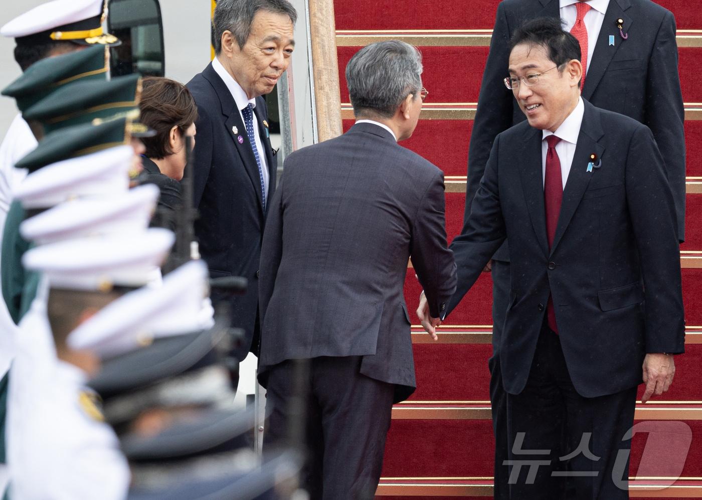 본문 이미지 - 기시다 후미오(岸田文雄) 일본 총리가 26일 경기도 성남시 서울공항에 도착, 김홍균 외교부 제1차관과 인사를 하고 있다. 윤석열 대통령은 리창 중국 국무원 총리, 기시다 후미오 일본 총리와 각각 회담을 한다(뉴스1DB)