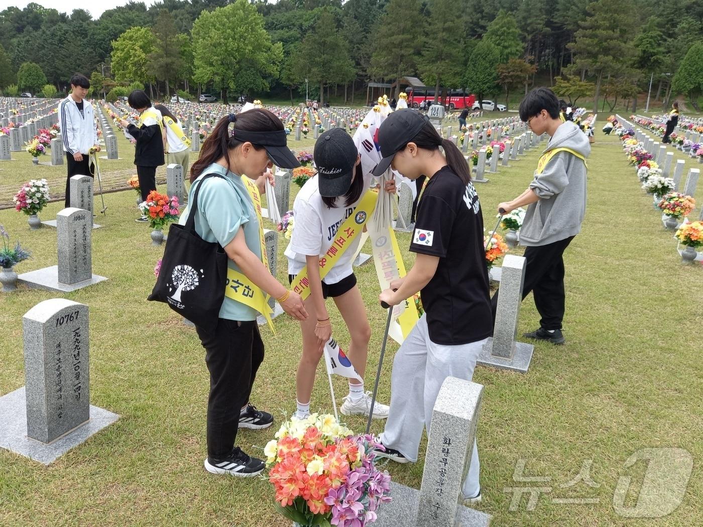 본문 이미지 - 충북 청주 오송고등학교 샤프론&프론티어봉사단(지도교사 홍정희)이 9년째 대전국립현충원을 찾아 묘역 정화 활동을 펼쳤다.(충북교육청 제공)/뉴스1
