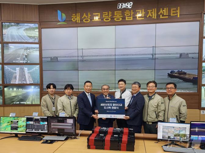 본문 이미지 - 27일 오전, 해상교량통합관제센터에서 미슐랭 스타셰프가 만든 도시락 전달식에서 관계자들이 기념사진을 찍고 있다(부산시설공단 제공)