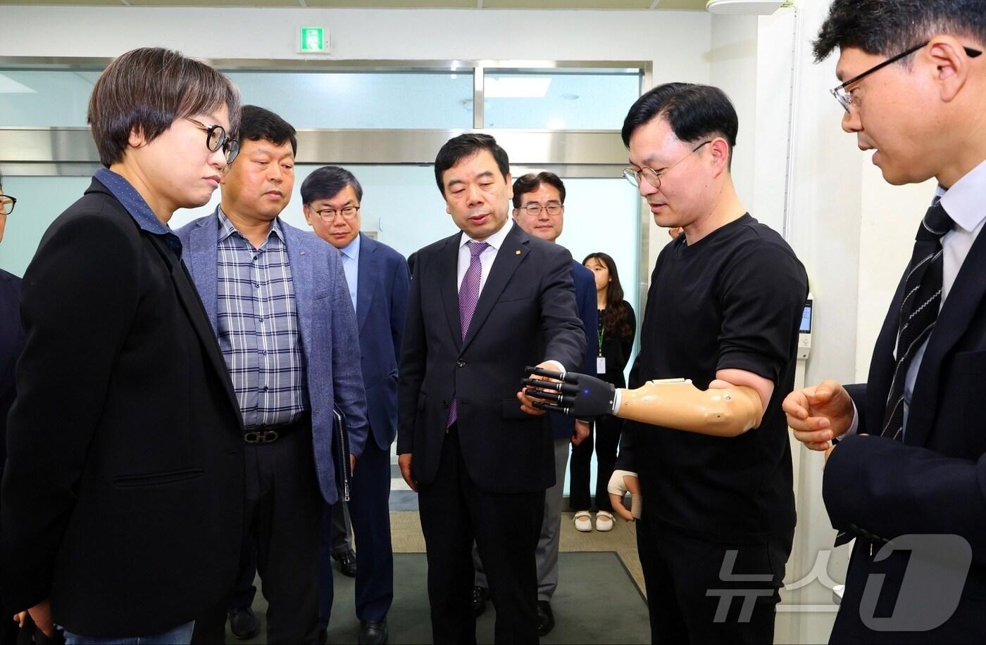 본문 이미지 - 박종길 근로복지공단 이사장(사진 중앙)과 이사들이 27일 공단산하 재활공학연구소에서 개최된 제308차 현장이사회에 참여후 바이오닉 기술이 적용된 재활보조기구를 살펴보고 있다. (사진제공=근로복지공단)