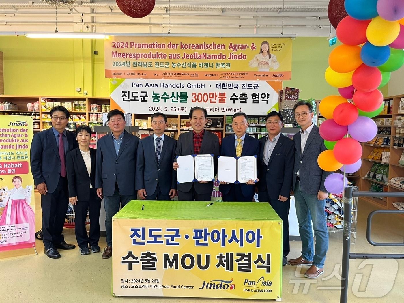 본문 이미지 - 김희수 군수(오른쪽 네 번째)를 비롯한 진도군 농수산물 수출개척단이 판아시아와 300만달러 수출 협약 체결한 뒤 기념사진을 찍고 있다.(진도군 제공)/뉴스1