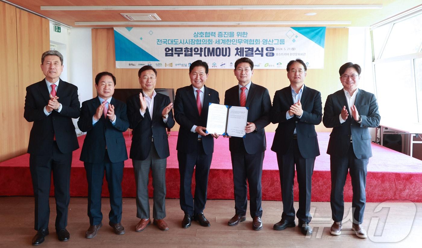 본문 이미지 - 월드옥타 회장을 맡고 있는 영산그룹 박종덕 회장과 전국대도시시장협의회 시장단이 업무협약 체결식에서 기념촬영을 하고 있다. 왼쪽부터 이강덕 포항시장, 주광덕 남양주시장, 신상진 성남시장, 박종범 회장, 이상일 용인시장, 이동환 고양시장, 김병수 김포시장.(용인시 제공)