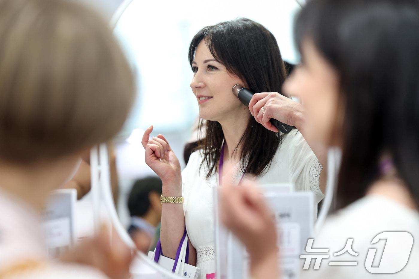 29일 오후 서울 강남구 코엑스에서 열린 '2024 서울국제화장품·미용산업박람회(코스모뷰티서울)·국제건강산업박람회(헬스&뷰티위크)'를 찾은 외국인 바이어들이 국산 미용 기기를 체험하고 있다. 2024.5.29/뉴스1 ⓒ News1 민경석 기자