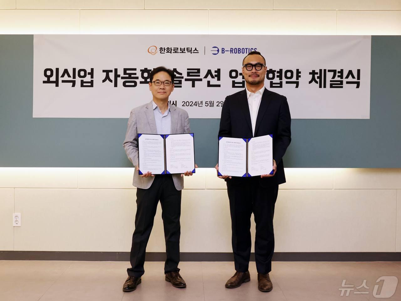 본문 이미지 - 서종휘 한화로보틱스 대표이사(왼쪽)가 김민수 비-로보틱스 대표이사와 외식업 자동화 솔루션을 위한 업무협약(MOU)을 체결하고 있다.(한화로보틱스 제공)