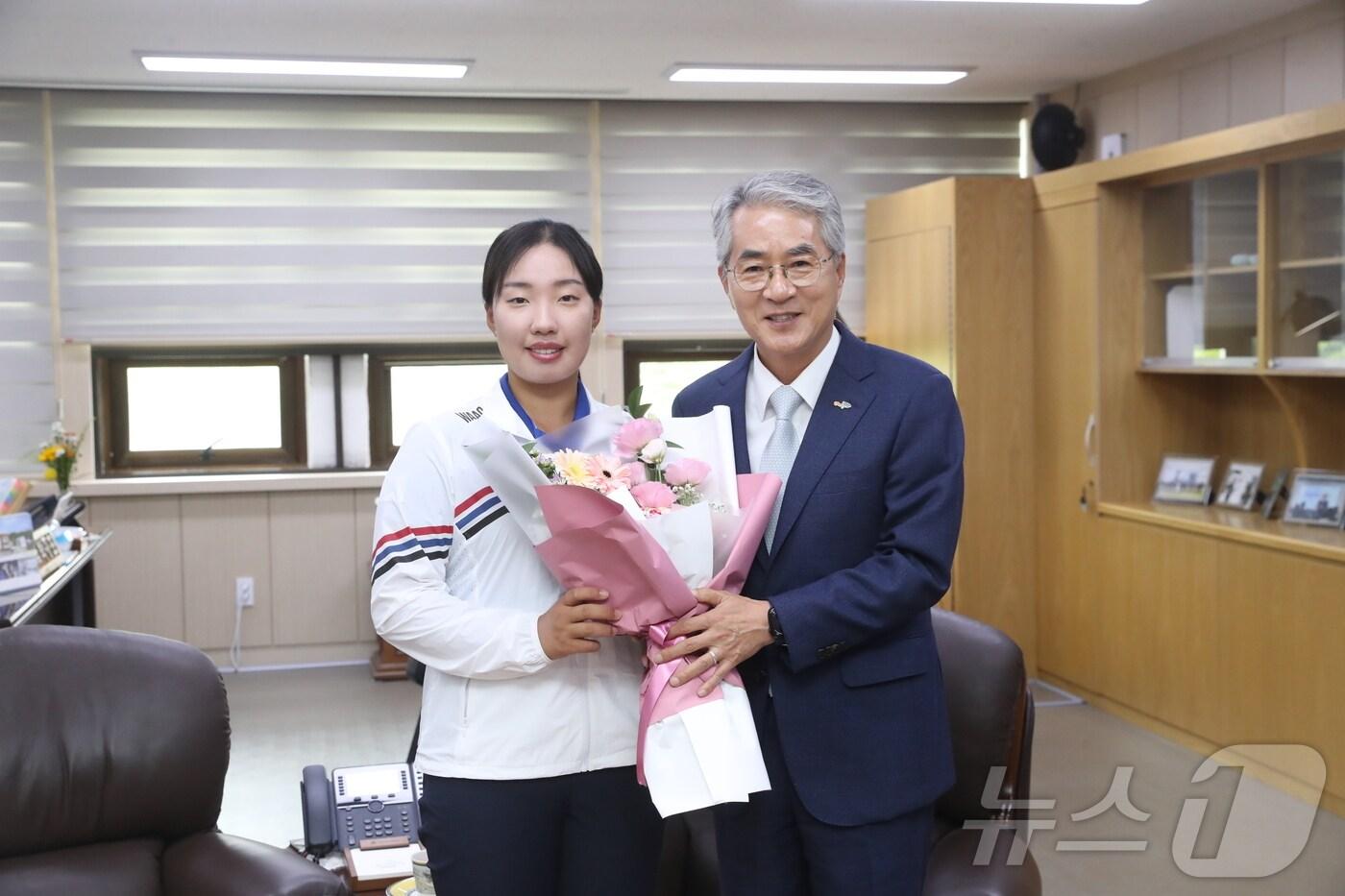 본문 이미지 - 박종훈 경남교육감이 30일 교육감 집무실에서 마산제일여고 이효송 선수에게 격려의 꽃다발을 전달한 뒤 함께 기념사진을 찍고 있다.(경남교육청 제공)