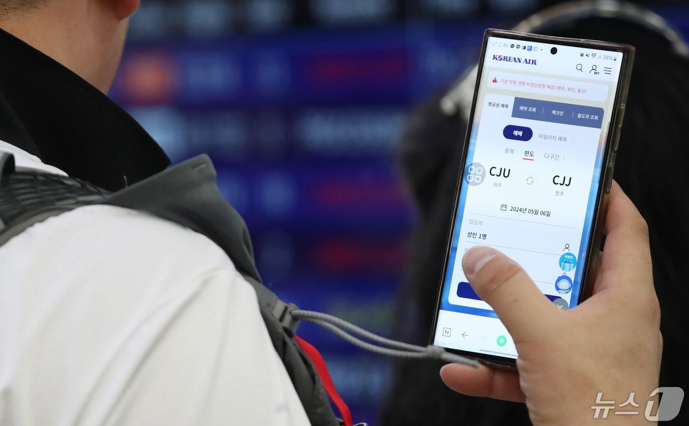 본문 이미지 - 제주국제공항 국내선 출발장에서 한 승객이 휴대전화로 항공권을 검색하고 있다. 기사 내용과 관련 없음./뉴스1 ⓒ News1 오현지 기자