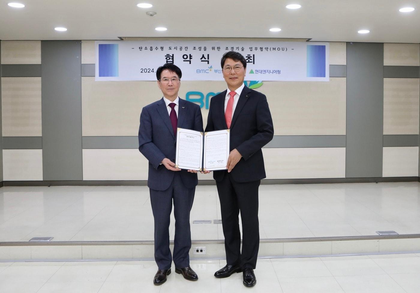 본문 이미지 - 지난 3일 부산도시공사에서 진행된 ‘탄소흡수형 도시공간 조성 업무협약 체결식’에서 홍현성 현대엔지니어링 대표이사(오른쪽)와 김용학 부산도시공사 사장(왼쪽)이 기념 촬영을 하고 있다.(현대엔지니어링 제공)