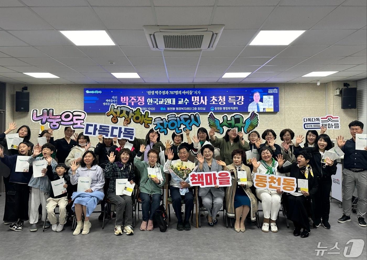 박주정 한국교원대학교 교수와 동천동 주민들이 지난 7일 광주 서구 동천동 행정복지센터 2층 회의실에서 '30년간 위기의 707명의 아이들 곁을 지킨 선생 박주정에 대한 이야기'를 주제로 강연을 마친 뒤 기념촬영하고 있다.(광주 서구 제공) 2024.5.8/뉴스1